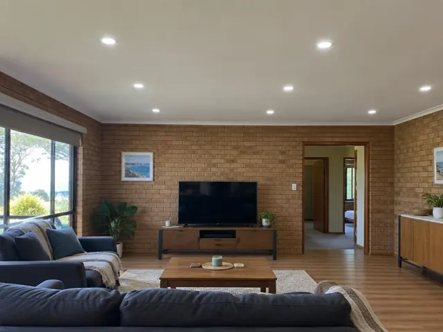 Living room with recessed LED downlights in a brick-walled home interior in Shelly Beach